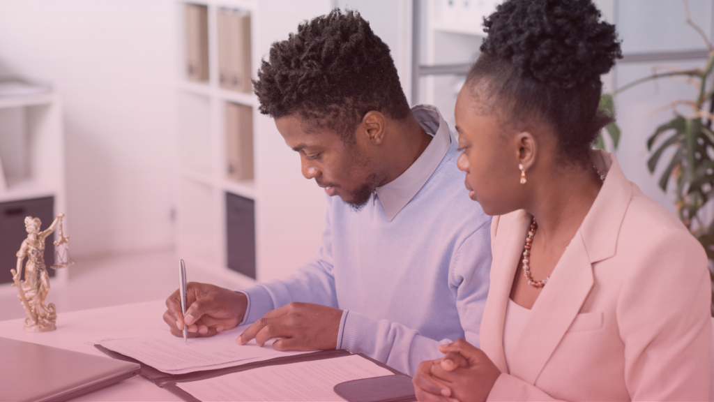 A couple signing documents after reaching proposals through mediation.