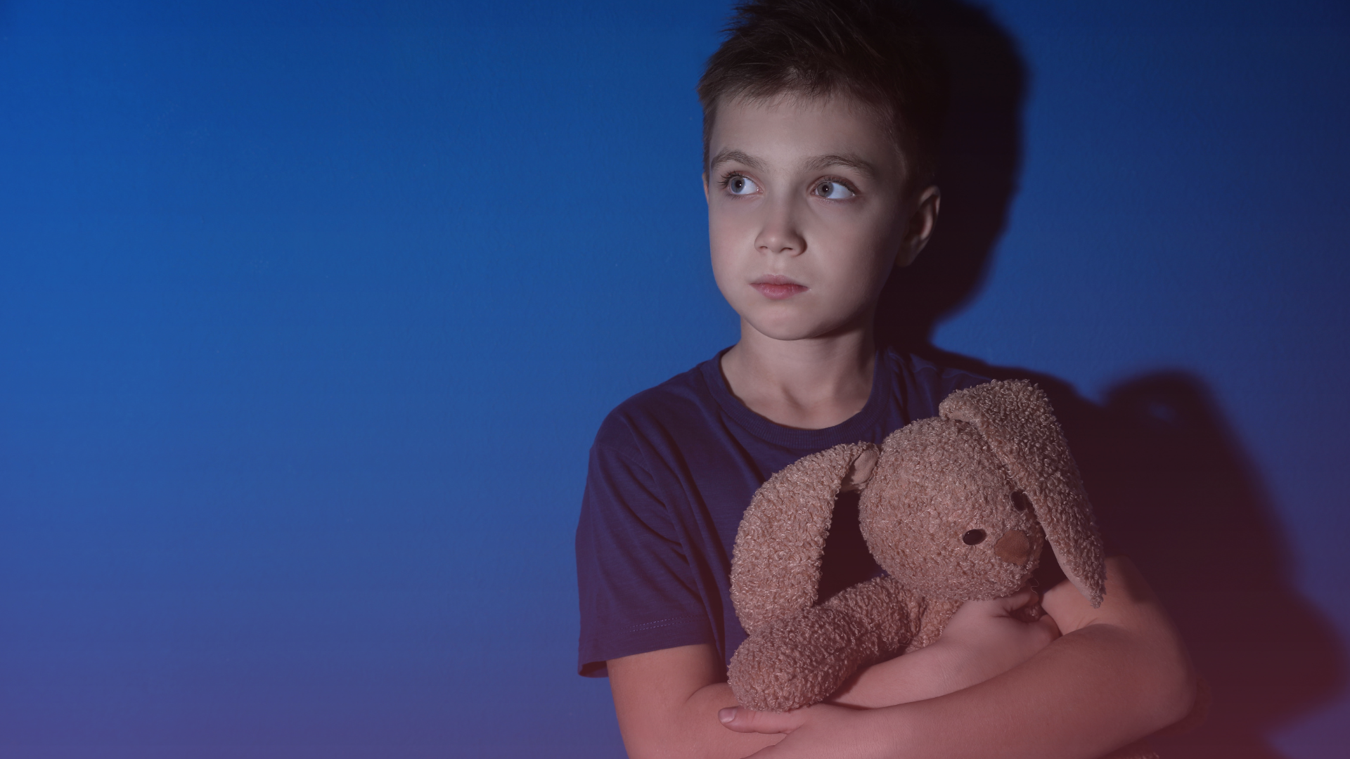 Sad Little Boy with Toy near Blue Wall, signifying MIAM exemption due to domestic violence within family