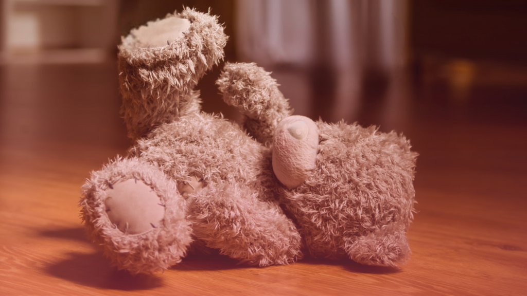 A child's teddy bear on the floor of a quiet bedroom, reflecting the distress caused when contact has broken down.